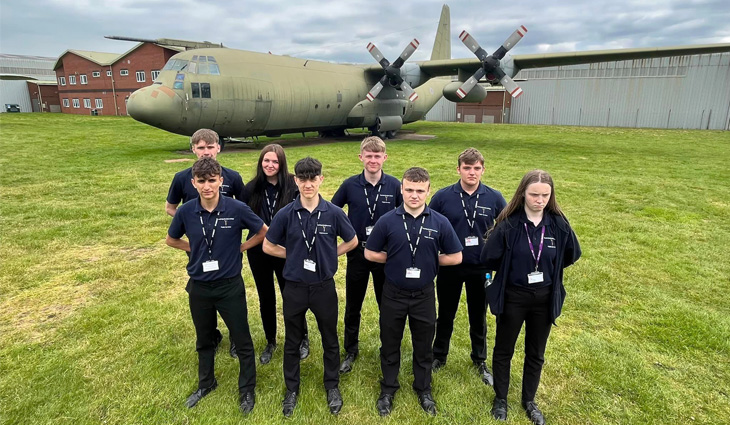 Level 2 Public Services group standing on grass in front of aircraft