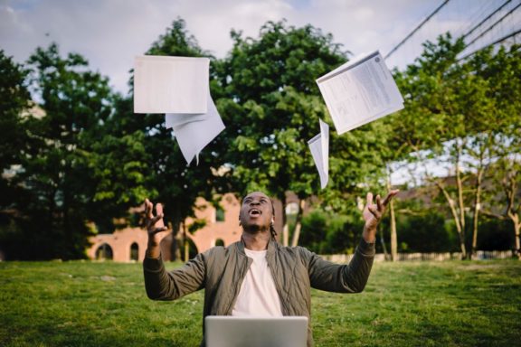 student throwing exam results in the air