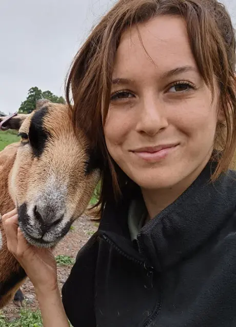 Adult taking a selfie with a goat
