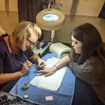 Beauty student giving nail treatment to a customer