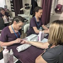 Beauty students delivering nail treatments to customers in beauty salon