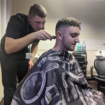 Student barber cutting a customers hair