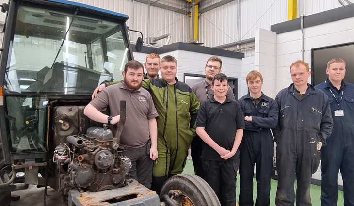 Group of Agricultural Engineering students standing by the side of a tractor