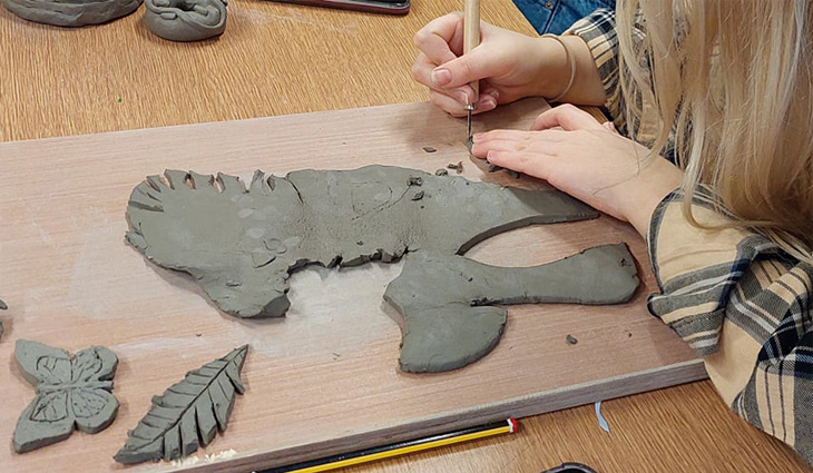 Art student sculpting with clay