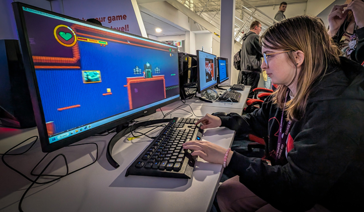 Photo of female Games Production student playing a computer game