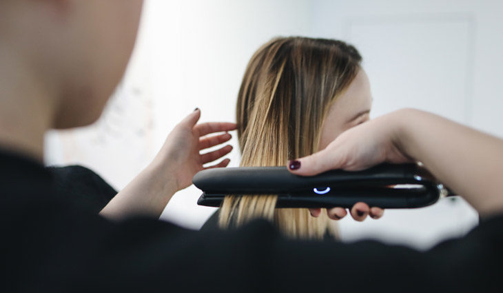 Hair being ironed by professional