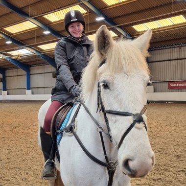 Photo of Equine student Lily Bradley sitting on the back of a horse