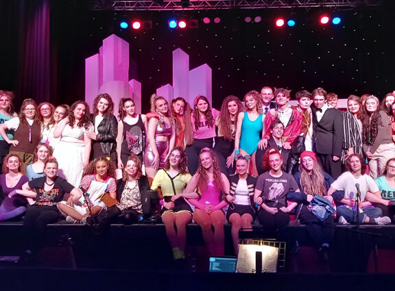 Group photo of our Performing Arts students on stage at the end of their show