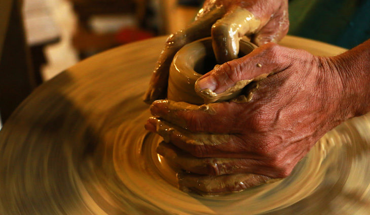 Person's hands using pottery wheel