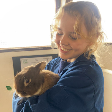 Photo of student Phoebe Yates holding a rabbit