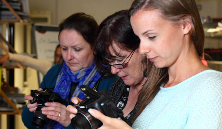 Photography Students Looking Through Cameras
