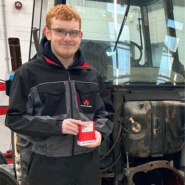 Agricultural engineering student Thomas Nock standing in front of tractor