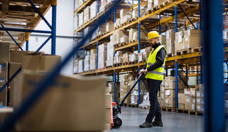 A male wearing a high-viz in a warehouse