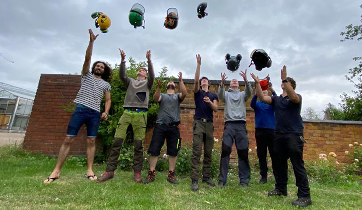 Photo of our arboriculture students all throwing their helmets into the air