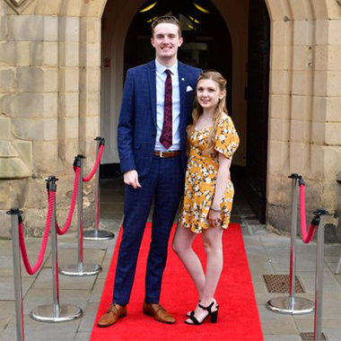 two Film & TV students standing on red carpet at premier event