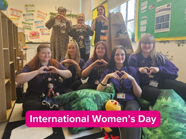 Early Years staff and students making hearts with their hands to celebrate International Women's Day