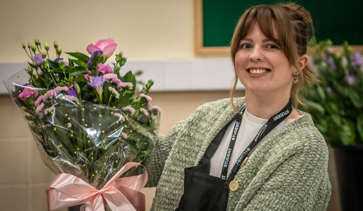 Photo of Floristry student Jade Owen holding a bouquet of flowers