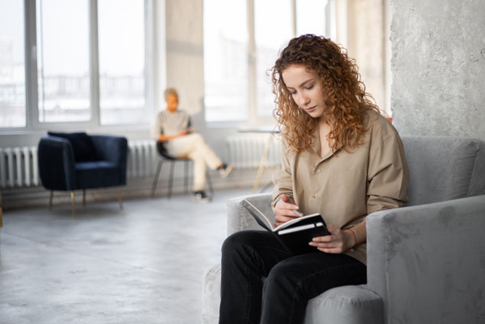 Woman reading a book on chair