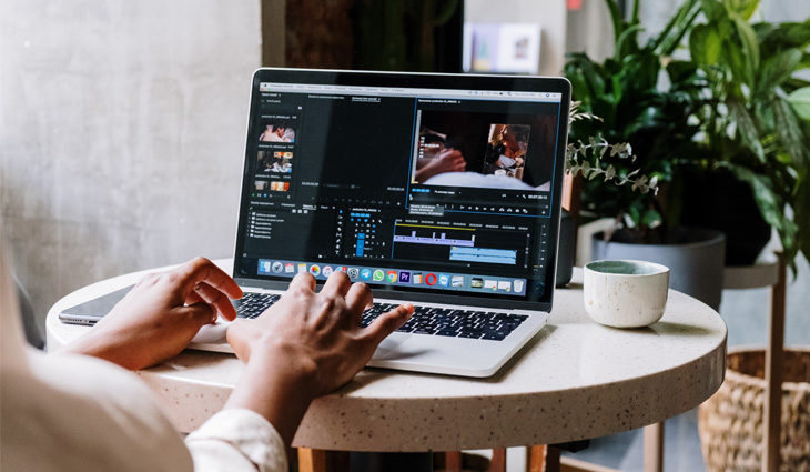 Person using premiere pro on laptop