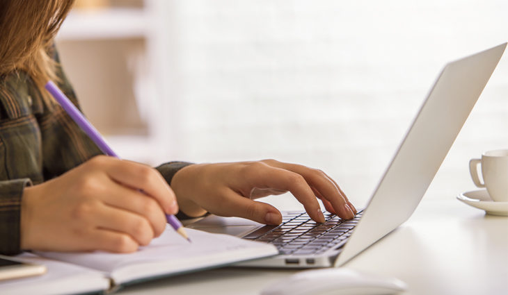 Student studying English on laptop at home