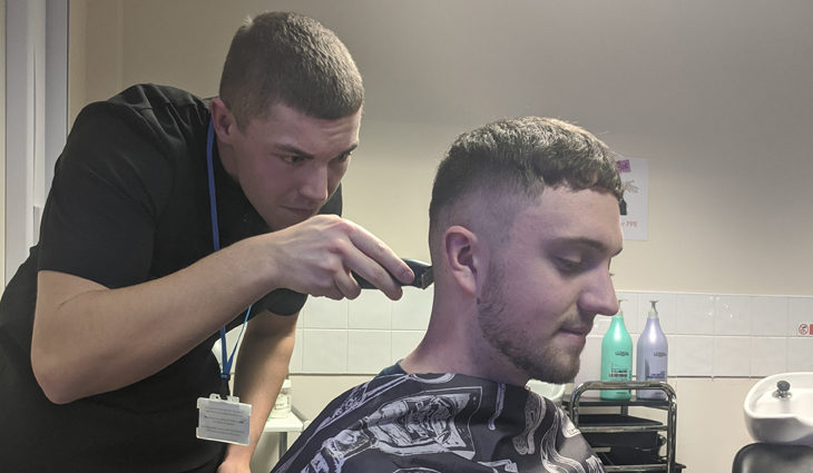 Barbering student cutting hair