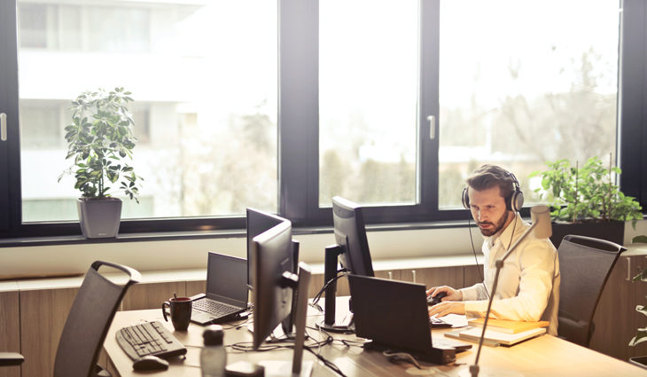 Man offering IT Support at Desk on Headset