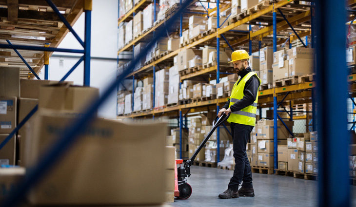 Man using pallet truck in a warehouse