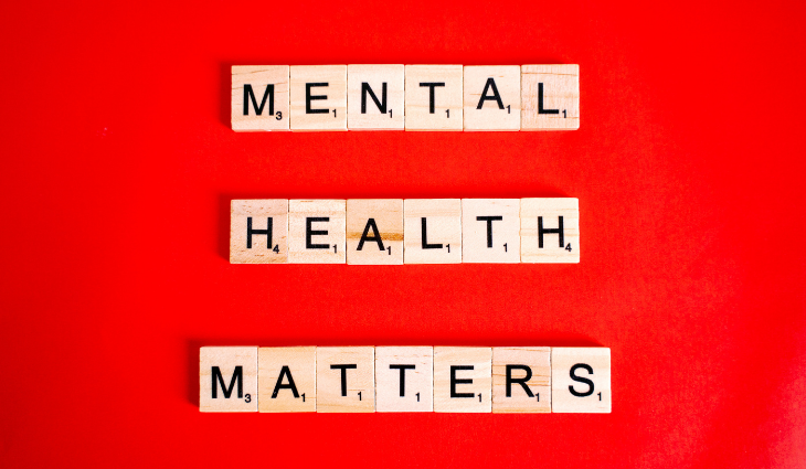 Scrabble tiles on red background spelling out mental health matters