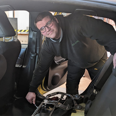 Photograph of Ryan Dudley working on a car in the colleges Automotive Training Centre