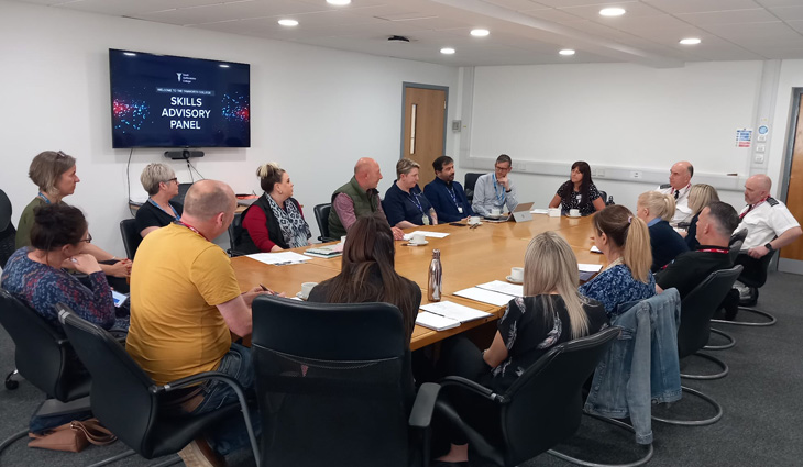 Staff and visitors sitting around a table at a Skills Advisory Panel