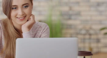 Girl smiling at laptop screen