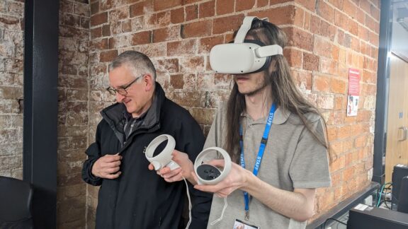 A member of staff and employer using VR headset