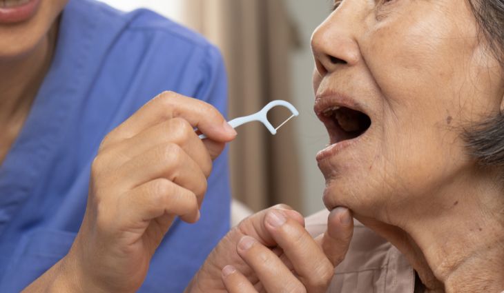 Healthcare worker using floss on woman