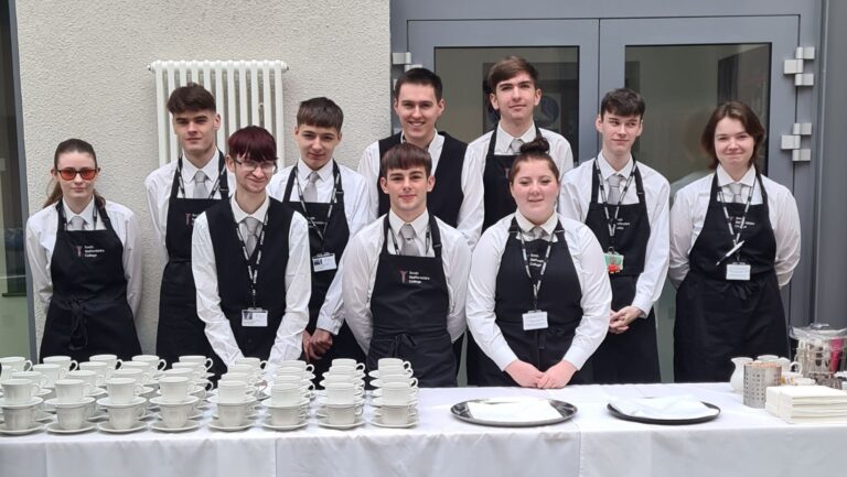 Catering learners serving guests at construction opening event