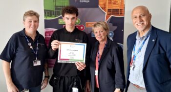Alfie Gibbs being presented with his certificate for his work in Tamworth on Verger Cottage